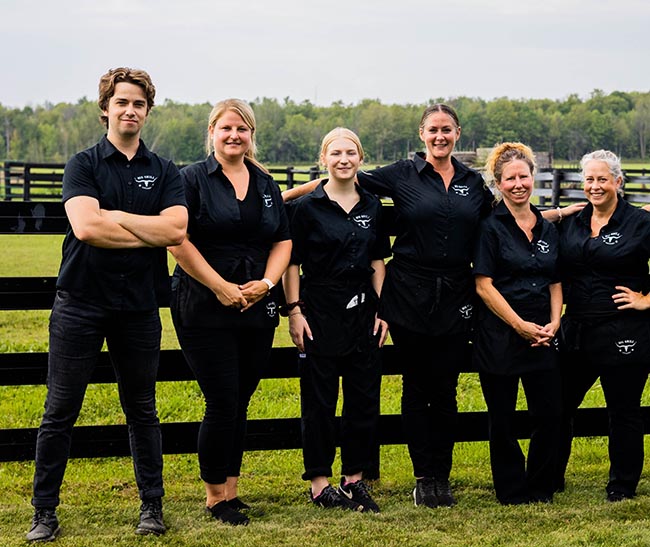 picture of big grill catering staff against a fence with a country background behind